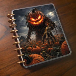 May include: A disc-bound notebook featuring a cover illustration of a glowing, menacing pumpkin-headed creature standing in a dark pumpkin patch under a cloudy sky, with a small house visible in the distance and gold-colored binding discs.