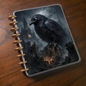 May include: A planner with a dark fantasy illustration. A large black raven with glowing white eyes perches atop a crumbling stone structure. A gothic cathedral and figures with torches are in the background.
