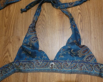 May include: A blue paisley patterned halter top with a silver button closure. The top is made of a soft, lightweight fabric and has a relaxed fit.