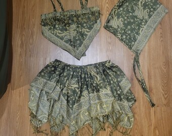 May include: A green and gold paisley patterned skirt, top, and head scarf set. The skirt is a-line and has a ruffled hem. The top is a halter style with fringe trim. The head scarf is a simple square shape.