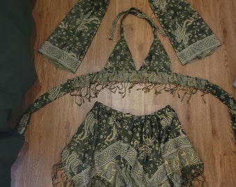 May include: A green and gold paisley print fabric set with a halter top, a skirt, and two sleeves. The fabric has a fringed edge.