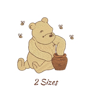 May include: Embroidered image of a seated tan bear with a brown honey pot. Three small bees are flying around the bear. The text "2 Sizes" is below the bear and honey pot.
