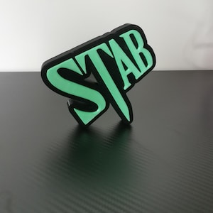 Könnte beinhalten: Ein schwarz-grünes 3D-gedrucktes Schild mit dem Wort "STAB" in fetten, weißen Buchstaben.