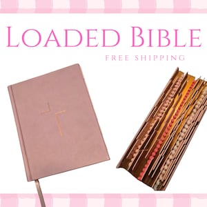 以下が含まれることがあります： 表紙に金の十字架が付いたピンク色の「LOADED BIBLE」と、カラフルなビーズが見える開いた本のセクション。本にはピンクのリボンのしおりが付いています。背景はピンクと白のチェック柄です。