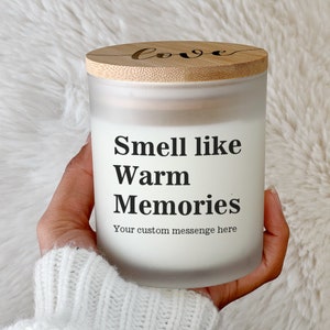 Op de afbeelding: Een witte, matte glazen kaars pot met een bamboe deksel. Het deksel heeft het woord "love" erop geschreven. De kaars pot heeft de tekst "Smell like Warm Memories" en "Your custom message here" erop gedrukt.