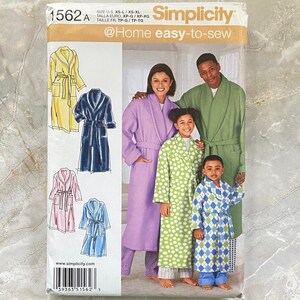 May include: Simplicity 1562 sewing pattern envelope for robes. The front shows illustrations of yellow, navy, pink, and blue robes. A photograph displays four people wearing robes in lavender, green, lime green with white dots, and blue with diamond patterns.