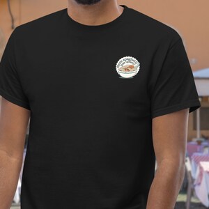 a man wearing a black t - shirt with a badge on it