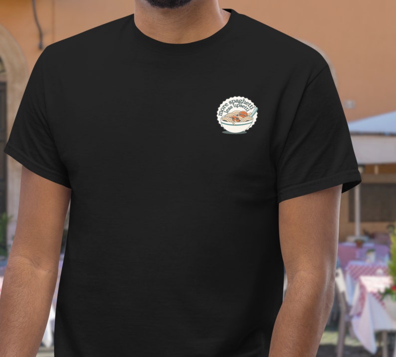 a man wearing a black t - shirt with a badge on it