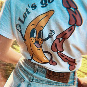 White T-Shirt with Retro Banana Design | Funny “Let’s Go Bananas” Graphic Tee | Vintage Banana Shirt | Quirky Foodie Unisex Tee | 90’s vibe