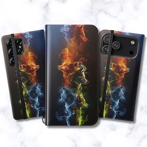 May include: Three smartphone cases featuring a vertical arrangement of wolf heads surrounded by swirling flames in shades of orange, yellow, blue, and green. The cases have a textured black surface and a black elastic band across the front.