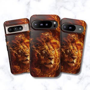 May include: Three smartphone cases featuring a high-resolution graphic of a lion's face surrounded by swirling orange and yellow flames. The design covers the back of each case, incorporating the camera lens cutout into the fiery artwork.