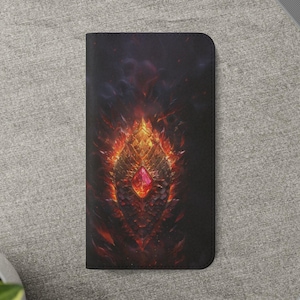 May include: Black wallet with a fiery, fantasy-themed design. The artwork features a central, jewel-like element in red, surrounded by flames and intricate, golden details. The background is dark, enhancing the vibrant colors.