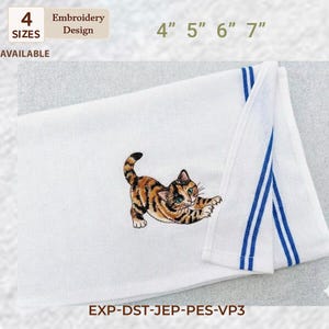 May include: White towel featuring an embroidered tabby cat design. The cat is brown, black, and orange with green eyes. The towel has blue stripes and is available in 4 sizes: 10 cm, 13 cm, 15 cm, and 18 cm.