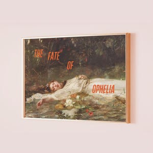 May include: Framed art print depicting a painting of a woman in a white dress in water. The artwork is titled "The Fate of Ophelia" in orange text. The frame is a light gold colour.