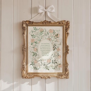 May include: A framed print with a gold ornate frame and a white ribbon bow. The print features a floral design with a quote in an oval shape. The quote reads: "You should think of your energy as if it's expensive..."