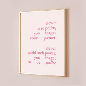 Może przedstawiać: Wydruk w ramie z różowym cytatem, który brzmi: "Nigdy nie bądź tak uprzejmy, aby zapomnieć o swojej mocy. Nigdy nie używaj tak dużej mocy, aby zapomnieć o uprzejmości."