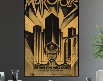 May include: A vintage movie poster for the 1927 German science fiction film "Metropolis." The poster features a black and gold color scheme with a stylized image of a futuristic city and a robot woman with large eyes. The text on the poster reads "Metropolis, Ein Film von Fritz Lang."