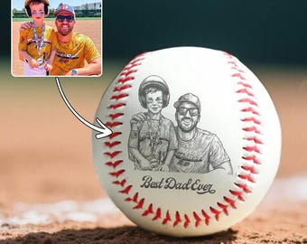 May include: A white baseball with red stitching, featuring a detailed sketch of a father and son, with the text "Best Dad Ever." An inset photo shows the same pair. Baseball is on a baseball field.