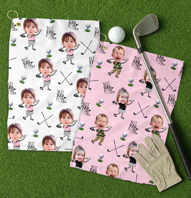 May include: Two golf towels with a repeating pattern of cartoon children, golf clubs, and golf balls. One towel is white, the other is pink. Text on the towels reads "BEST DAD BY PAR". A golf club, ball, and glove are also present.