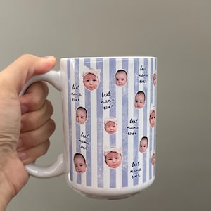 May include: White ceramic mug with a blue and white striped pattern. The mug is decorated with baby photos and the text "best mama ever". The mug has a white handle.