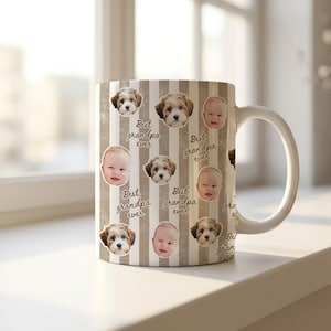 May include: A white ceramic mug with a handle, decorated with a repeating pattern of baby faces, puppy faces, and the text "Best grandpa ever" on a striped background. The mug is sitting on a white surface.