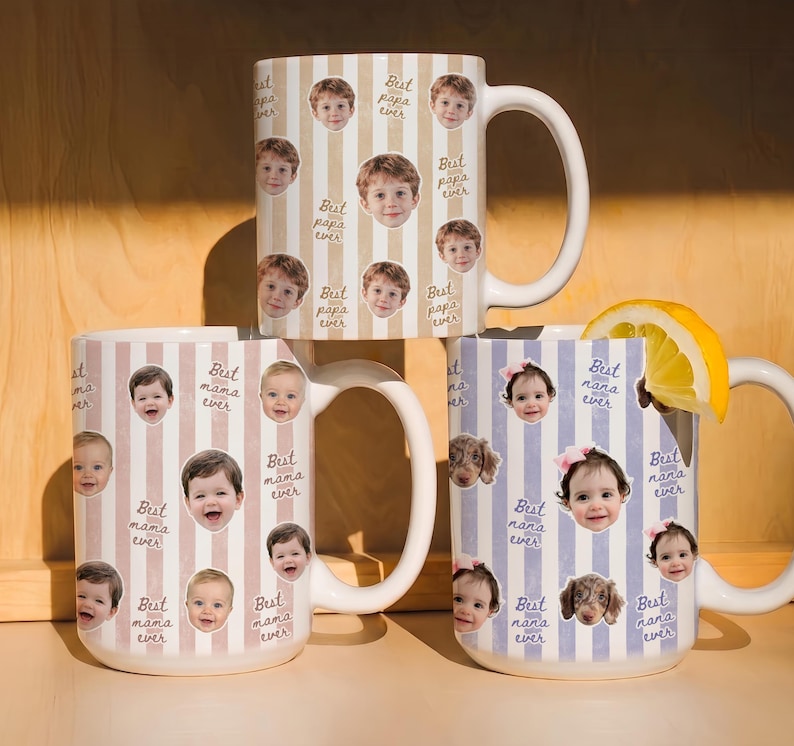 May include: Three white ceramic mugs with large handles. Each mug features a vertical striped pattern and is decorated with photos of children and the phrases "Best papa ever", "Best mama ever", and "Best nana ever". One mug has a lemon slice.