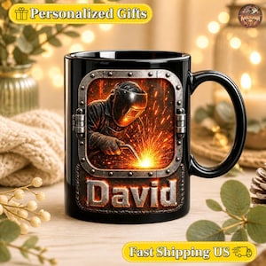 May include: A black ceramic mug featuring a graphic of a welder wearing a protective helmet and using a torch to create bright orange sparks. The graphic is framed by a metallic porthole design, and the name David is printed in metallic letters.