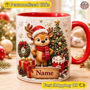 May include: A white ceramic mug with a red interior and handle, featuring a 3D-style illustration of a reindeer wearing a red hat and scarf, a decorated Christmas tree, a wreath, a gift box, a mug of hot cocoa, and a wooden sign labeled Name.