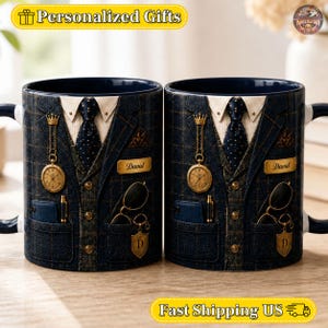 Puede incluir: Dos tazas de cerámica con un diseño estampado de chaqueta de traje a cuadros azul oscuro, camisa blanca y corbata de lunares azul oscuro. El diseño incluye un reloj de bolsillo dorado, una placa con el nombre David, un bolígrafo y gafas.