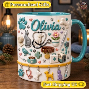 Puede incluir: Una taza de cerámica blanca con interior y asa de color verde azulado, con el nombre Olivia en letra cursiva. La taza está decorada con iconos 3D en relieve de un gato, un perro, un estetoscopio, una jeringuilla, un transportín y huellas.