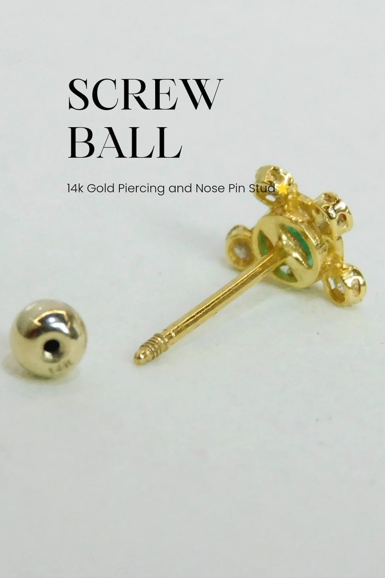 May include: A gold screw ball nose piercing with a small green stone in the center. The screw ball is surrounded by small clear stones. The piercing is 14k gold.