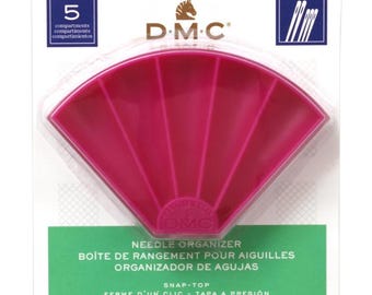 May include: A pink plastic needle organizer with 5 compartments. The organizer has a snap-top closure and is labeled "DMC Needle Organizer, Boite de Rangement pour Aiguilles, Organizador de Agujas, Snap-Top, Ferme d'un Clic - Tapa a Presion".