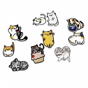 May include: A collection of embroidered cat patches in various colors and poses. The patches include cats in different positions, such as sitting, lying down, and playing. Some patches feature cats with accessories like a fishbowl or cupcake.