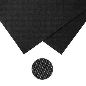 May include: Two pieces of black fabric with a textured surface are displayed, along with a small, round, black object with a dotted pattern. The fabric pieces are folded, showing their edges. The round object is a coaster.