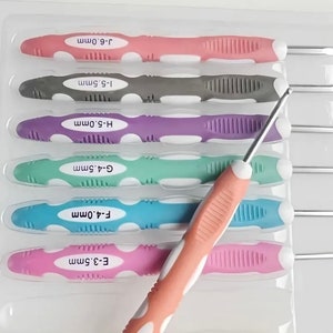 May include: Set of 8 crochet hooks with colorful polka dot handles. The hooks are labeled with their size in millimeters: E-3.5mm, F-4.0mm, G-4.5mm, H-5.0mm, I-5.5mm, J-6.0mm.
