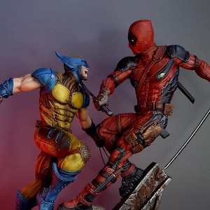 Può includere: Una action figure di Deadpool rossa e nera sta combattendo contro una action figure di Wolverine gialla e blu. Le figure sono in posa in una scena di battaglia dinamica su una base grigia e marrone.