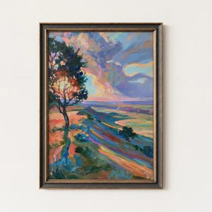 May include: A framed landscape painting featuring a solitary tree on a hillside overlooking a valley. The artwork uses vibrant brushstrokes of orange, blue, purple, and yellow to depict a sunset sky and rolling terrain in a textured, expressive style.