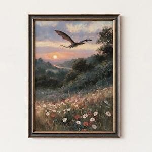 May include: A framed wall art print featuring a landscape painting of a dragon flying over a meadow filled with white and red wildflowers at sunset. The scene includes rolling hills, trees, and a river under a cloudy sky in a dark wooden frame.