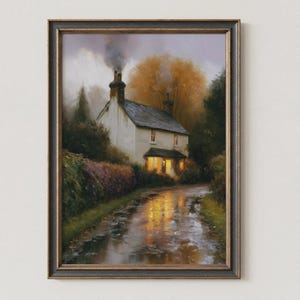 May include: A framed oil painting depicting a white cottage with a smoking chimney at dusk. The house features glowing yellow windows that reflect onto a wet, muddy path in the foreground. Surrounded by autumn trees and dark foliage.
