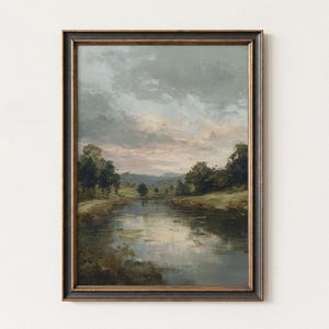 May include: An oil painting in a black and gold frame depicts a serene landscape. The artwork showcases a reflective body of water, lush green banks, and a cloudy sky with hints of pink and gray. The painting evokes a sense of tranquility.