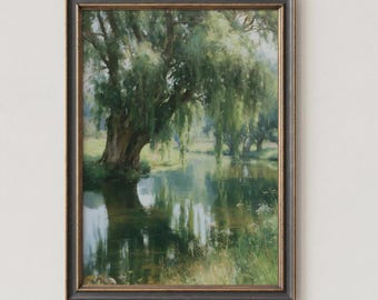 May include: A framed landscape painting depicting a large willow tree with drooping green branches overhanging a calm river. The scene features soft light, reflections on the water surface, and grassy banks, all enclosed within a dark, textured frame.