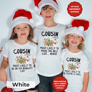 May include: Three white t-shirts featuring the text COUSIN crew and illustrations of a reindeer, Christmas tree, gingerbread person, and snowman. Each shirt has unique text below the graphic. The shirts are worn with red and white Santa hats.