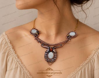 May include: A copper-toned wire-wrapped necklace featuring three oval-shaped, pale blue cabochon stones and one small, round, deep orange bead. The intricate metalwork includes coiled wire details and a gold-toned chain connecting the central piece.