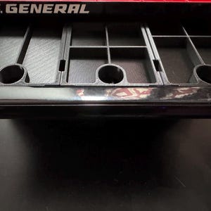 Puede incluir: Un caj&oacute;n negro con un inserto gris texturizado y compartimentado. El caj&oacute;n est&aacute; abierto y el inserto es visible. El caj&oacute;n est&aacute; etiquetado con "U.S. GENERAL" en letras blancas.