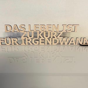 May include: Wooden sign with the text "Das Leben ist zu kurz für irgendwann" in German.