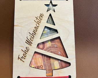 May include: A wooden Christmas tree card with a red string and the text "Frohe Weihnachten" in German. The card has slots to hold money.
