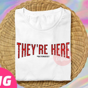 Könnte beinhalten: Weißes T-Shirt mit dem Text "They're Here" in Rot mit einem Used-Look. Der Text "Poltergeist" ist in Schwarz unter dem Haupttext gedruckt.
