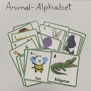 Op de afbeelding: Een set flashcards met verschillende dieren met hun bijbehorende letter van het alfabet. De kaarten zijn groen met witte randen en bevatten kleurrijke illustraties van dieren zoals een bij, een alligator, een octopus en een giraffe. De tekst "Animal-Alphabet" staat bovenaan de afbeelding.