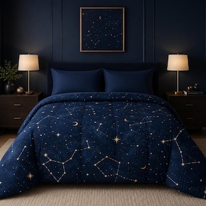 May include: A navy blue comforter featuring a gold celestial print of stars, constellations, and crescent moons. The bedding set includes two matching navy blue pillow shams, creating a cohesive look with a dark blue background and gold accents.