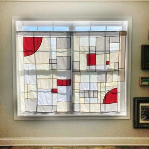 May include: A pair of window curtains featuring a geometric patchwork design composed of rectangular and square panels in white, off-white, and gray, accented by solid red blocks and partial red circular segments outlined in dark gray lines.